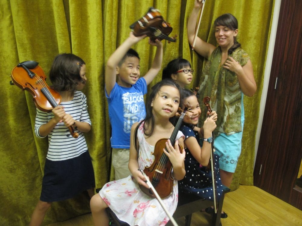 young kids experimenting with violins at Tanglewood Music School Bukit Timah
